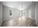 Large bedroom with sleek wood floors, modern ceiling fan, and bright natural light through two windows at 12690 Ne Highway 315, Fort Mc Coy, FL 32134