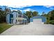 Charming blue two-story home with a metal roof, carport, detached garage, and green lawn at 12690 Ne Highway 315, Fort Mc Coy, FL 32134