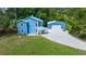 Bright blue two-story home with a metal roof, detached garage, carport, and long driveway at 12690 Ne Highway 315, Fort Mc Coy, FL 32134