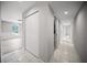 Hallway with white doors, tile floor, and view into a bright room with wainscoting at 12690 Ne Highway 315, Fort Mc Coy, FL 32134