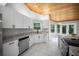 Bright kitchen featuring white cabinetry, granite countertops, and a wooden ceiling at 12690 Ne Highway 315, Fort Mc Coy, FL 32134