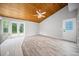 Spacious living room with hardwood floors and a wood ceiling, leading to a tiled kitchen area at 12690 Ne Highway 315, Fort Mc Coy, FL 32134
