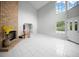 Spacious living room features a brick fireplace, large windows, and white tile flooring at 12690 Ne Highway 315, Fort Mc Coy, FL 32134