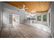 Open-concept living area featuring wood floors, a wood ceiling, and a view into the kitchen at 12690 Ne Highway 315, Fort Mc Coy, FL 32134