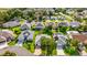 An aerial view showcasing a residential area with multiple homes and mature trees at 1308 La Estrellita Way, The Villages, FL 32162