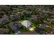 An aerial view of a home with a screened-in lanai, nestled in a quiet neighborhood with mature trees at 1308 La Estrellita Way, The Villages, FL 32162