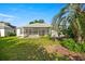 Landscaped backyard featuring a screened-in patio and green lawn at 1308 La Estrellita Way, The Villages, FL 32162