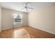 A well-lit bedroom with laminate floors, a ceiling fan, and a window covered with sheer white curtains at 1308 La Estrellita Way, The Villages, FL 32162