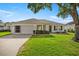 Charming single-story home with a well-maintained lawn and attached garage, under a blue sky at 1308 La Estrellita Way, The Villages, FL 32162