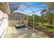 Screened-in patio featuring a hot tub and landscaping at 1308 La Estrellita Way, The Villages, FL 32162