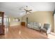 Bright living room featuring wood floors, a ceiling fan, and a view into the kitchen at 1308 La Estrellita Way, The Villages, FL 32162