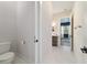 Bright bathroom featuring a vanity, toilet, and entrance to the main bedroom, showcasing modern design and functionality at 13663 Sw 66Th St, Ocala, FL 34481