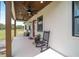 Inviting covered porch with ceiling fans and black rocking chairs at 13663 Sw 66Th St, Ocala, FL 34481