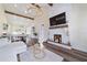 Open living space featuring a stone fireplace, wood beams, and elegant chandelier at 13663 Sw 66Th St, Ocala, FL 34481