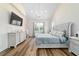 Main bedroom featuring vaulted ceilings, chandelier, wood floors, TV, dresser, and windows at 13663 Sw 66Th St, Ocala, FL 34481