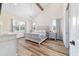 Main bedroom featuring vaulted ceilings, chandelier, wood floors, windows, and ensuite bathroom at 13663 Sw 66Th St, Ocala, FL 34481
