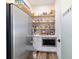 Walk-in pantry with shelves, microwave, and countertop next to a stainless steel refrigerator at 13663 Sw 66Th St, Ocala, FL 34481
