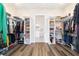 Spacious walk-in closet with hardwood floors, shelving, hanging racks, and leading to the bathroom at 13663 Sw 66Th St, Ocala, FL 34481
