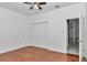 A clean bedroom with hardwood floors, ceiling fan, closet, and entrance to bathroom at 14550 Sw 61St Ct, Ocala, FL 34473