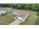 Aerial view showcasing the single-story home with a neutral gray paint scheme, brown roof, long driveway, and two-car garage at 14550 Sw 61St Ct, Ocala, FL 34473