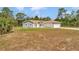 Single-story home featuring a neutral gray paint scheme, brown roof, and long driveway with an attached two-car garage at 14550 Sw 61St Ct, Ocala, FL 34473