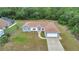 Aerial view of a single-story home with neutral gray paint, brown roof, an attached two-car garage, and a long driveway at 14550 Sw 61St Ct, Ocala, FL 34473