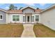 Close up of the main entry, walkway, and landscaping of this single-story home with a two-car garage and neutral gray paint at 14550 Sw 61St Ct, Ocala, FL 34473