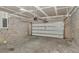 Unfinished garage featuring block walls and a partially open garage door at 14550 Sw 61St Ct, Ocala, FL 34473