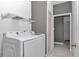 Bright laundry room features modern washer and dryer, wire shelving, and gray accent wall at 14550 Sw 61St Ct, Ocala, FL 34473