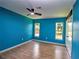 Bright bedroom with blue walls, wood floors, a ceiling fan, and natural light at 1610 Se 22Nd Ave, Ocala, FL 34471