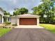 Attached two-car garage featuring a brown garage door, modern lighting, and a paved driveway leading to the home at 1610 Se 22Nd Ave, Ocala, FL 34471