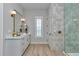 Modern bathroom features a spacious vanity, neutral tile walls, and a glass-enclosed shower with modern gold accents at 1631 W Hwy 329, Citra, FL 32113