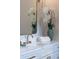 Close up of a modern bathroom vanity with marble countertop, gold fixtures, and decorative orchids in a colorful vase at 1631 W Hwy 329, Citra, FL 32113