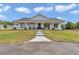 Inviting front of the home, featuring a covered porch and walkway, surrounded by beautiful landscaping at 1631 W Hwy 329, Citra, FL 32113