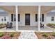 Welcoming front porch featuring a stone walkway, black front door, and Adirondack chairs at 1631 W Hwy 329, Citra, FL 32113