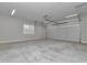 Large two-car garage featuring an automatic garage door, smooth concrete floor, and window at 1631 W Hwy 329, Citra, FL 32113