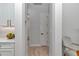 Bright hallway leads to kitchen with white cabinetry and wood-look floors at 1631 W Hwy 329, Citra, FL 32113
