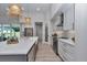 Bright, white kitchen boasts an island with marble countertop, gold faucet and pendant lights at 1631 W Hwy 329, Citra, FL 32113