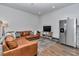 Cozy living room with a leather sectional, a TV, stainless steel fridge, and hardwood floors at 1631 W Hwy 329, Citra, FL 32113