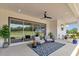 Relaxing covered patio with seating area, ceiling fan, and a view of the lush green field at 1631 W Hwy 329, Citra, FL 32113