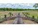 Grand gated entrance with a winding driveway leading to a vast estate, framed by lush landscapes and serene greenery at 1631 W Hwy 329, Citra, FL 32113