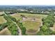 Aerial view of the sprawling property showcasing the house, barns, and surrounding greenery at 1631 W Hwy 329, Citra, FL 32113