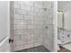 Modern tiled walk-in shower featuring a black pebble floor in a renovated bathroom at 1631 W Hwy 329, Citra, FL 32113