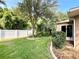 Home's backyard with a white fence, mature tree, landscaped area, and view of the home's back facade at 16405 Sw 14Th Avenue Rd, Ocala, FL 34473