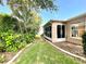 Landscaped backyard with lush greenery bordering home and leading to a sunroom with large windows at 16405 Sw 14Th Avenue Rd, Ocala, FL 34473