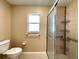 Bright bathroom features a toilet, window, and shower with handrail at 16405 Sw 14Th Avenue Rd, Ocala, FL 34473