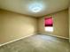 Bright bedroom features carpet and a window with a red shade at 16405 Sw 14Th Avenue Rd, Ocala, FL 34473