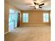 Spacious carpeted bedroom features neutral paint, a ceiling fan, and plantation shutters on two large windows at 16405 Sw 14Th Avenue Rd, Ocala, FL 34473