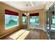 Bright breakfast nook with wood floors, modern chandelier, windows and sliders to screened lanai and backyard at 16405 Sw 14Th Avenue Rd, Ocala, FL 34473