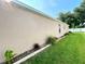 Exterior side of tan home featuring green grass and manicured landscaping at 16405 Sw 14Th Avenue Rd, Ocala, FL 34473